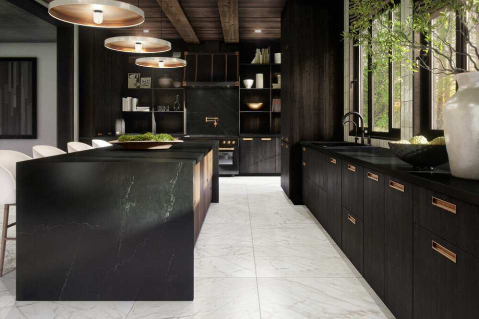 white marble floor in black kitchen with brass accents, wood beams, and greenery